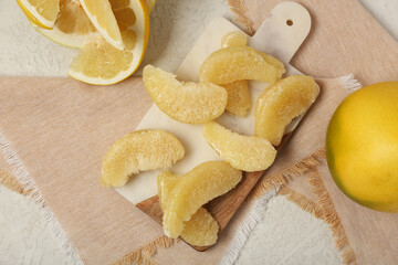 Board with tasty pomelo pieces on white background