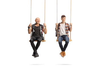 Punk and a male student sitting on swings and looking at camera