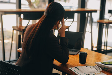 Asian women are stressed while working on laptop, Tired asian businesswoman with headache at office, feeling sick at work, copy space - obrazy, fototapety, plakaty