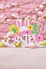 Easter decoration with Easter eggs and bunny on a pink background. Happy Easter