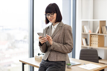 Smiling manager in suit developing electronic communication using wireless connection. Joyful...