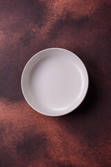Empty ceramic round plate on dark textured concrete background