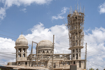 A new mosque under construction, building a new grand Masjid mosque in Ethiopia, with a big dome and high minaret, wooden scaffolds.