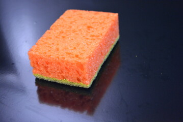 Things that are often used in the household. Colored washcloths for washing dishes are arranged on a glossy black background.