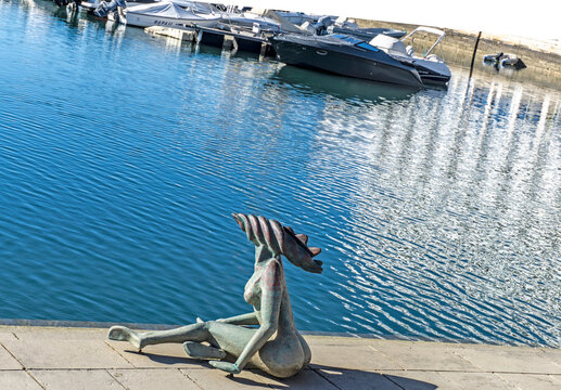 The statue of a mermaid sitting in the port of Faro, Portugal.