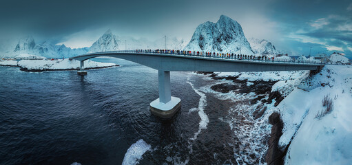 Lofoten Islands, Reine, Norway and bridge to Hamnoy fishing village with red rorbuer houses in winter nature panorama landscape - 740283320