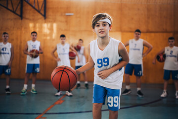 An active junior basketball player dribbling a ball towards camera.
