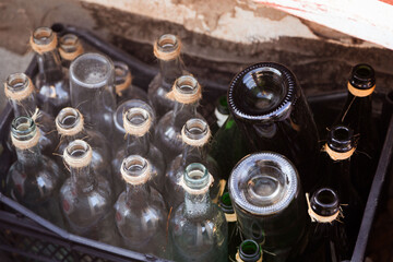 Assorted empty glass bottles with twine, in a crate, for eco recycling themes, perfect for travel and lifestyle media