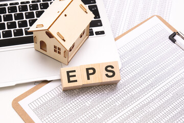 EPS - word on wooden cubes on a white background with a table, laptop keyboard and a small wooden...