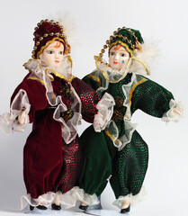 Two Porcelain Italian dolls depicting the hero of the Commedia Del Arte in red and green costumes. - 740301903