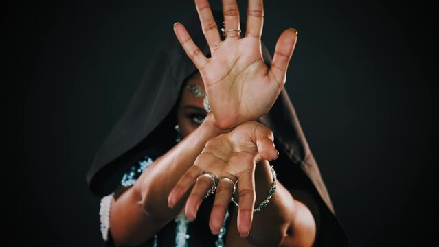 Closeup portrait fantasy african american woman voodoo witch conjuring ritual traditional. Art dance hands. Girl goth vampire dances hypnotizes sexy finger slow motion. mystical face. Black dress hood
