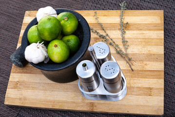 board with seasonings in mortar such as lemon, garlic, thyme, salt and pepper for culinary use