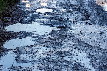 Pot holes filled with rain water causing a hazard on a country road in Sussex