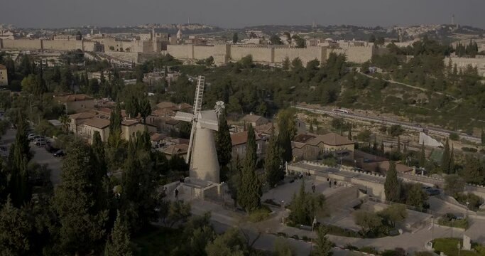 Aerial Footage of the Montefiore Windmill which was built in 1858 in the Mishkenot Sha'ananim neighborhood in Jerusalem. In the background are the walls of the Old City and the Tower of David.