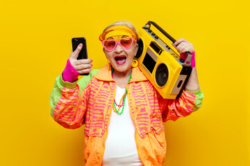 shocked crazy funny granny in hipster clothes listening to loud music on tape recorder online and...