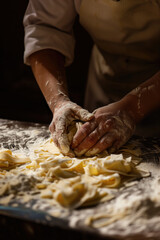 Close-up of a male bakery chef making Italian pasta - obrazy, fototapety, plakaty