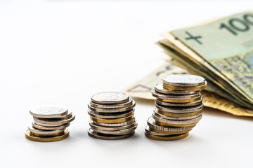 Polish zloty banknotes and coins. Polish currency. Polish zloty coins stacked on each other in...