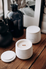 Aromatic candles made of soy in glass and plaster or concrete jars, boxes. Bath candles. Modern handmade candles without paraffin from coconut wax. Wooden wick. Elegant home decoration with a wooden w