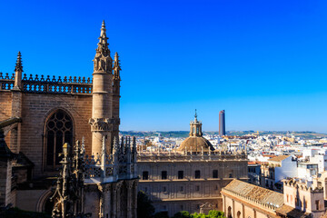 Fototapeta na wymiar View from the Giralda Tower out over the roof and spires of the Seville cathedral with the city in view in Seville, Spain