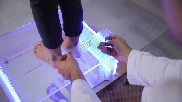 A person is getting their feet measured by a doctor