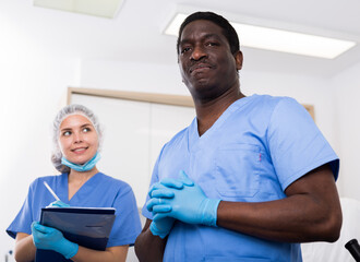 Obraz premium Portrait of two smiling successful male and female beauticians in modern clinic of esthetic medicine