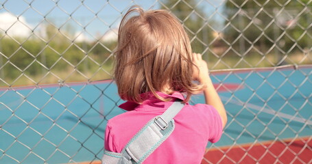 A child with a broken arm outdoors near a playground fence. The concept of health, injuries related...