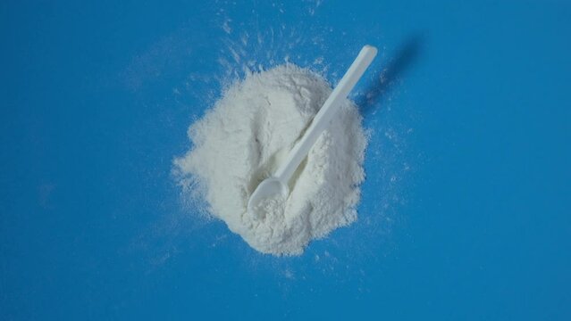 Pile of Sodium Carboxymethyl Cellulose Powder, NaCMC with measuring spoon. Food additive E466, impart of property enhancements that bring high stability of texture food and beverages. 