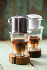 Vietnamese coffee in glass cups on old boards, phin filter