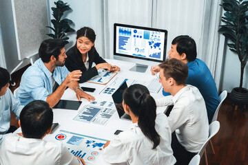 Analyst team utilizing BI Fintech to analyze financial data at table in meeting room....