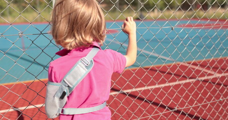 A child with a broken arm outdoors near a playground fence. The concept of health, injuries related...