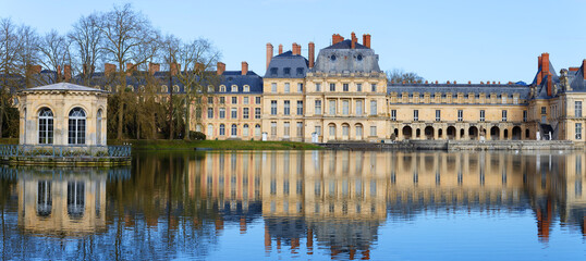 Beautiful Medieval landmark - royal hunting castle Fontainbleau with reflection in water of pond. - 740321717
