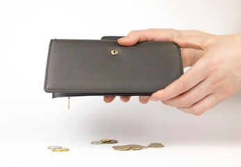 Coins falling out of a wallet. A leather wallet in the hands of a woman. Coins are falling out of...