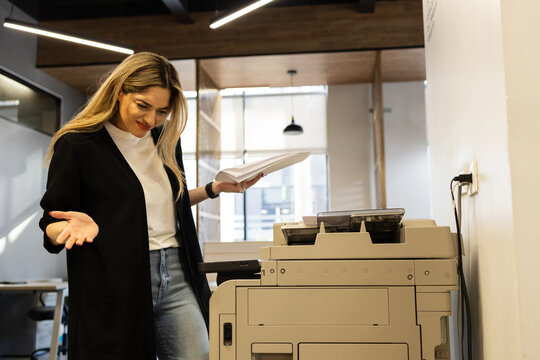 Woman having problems with a photocopier at work