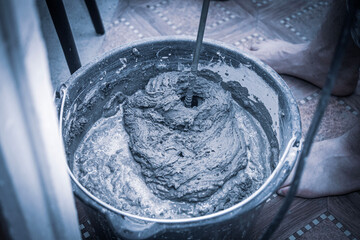 knead the solution with a mixer in a bucket of cement and sand