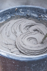 knead the solution with a mixer in a bucket of cement and sand