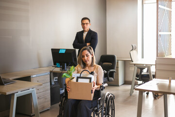 Woman in a wheelchair getting fired from her job while her boss stands behind her
