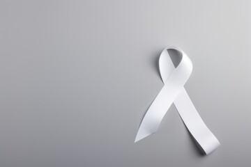 Lung cancer awareness concept with a single white ribbon on a gray surface. Lung Cancer Awareness Ribbon