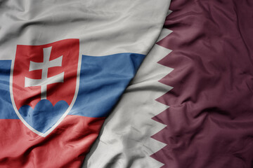 big waving national colorful flag of qatar and national flag of slovakia .