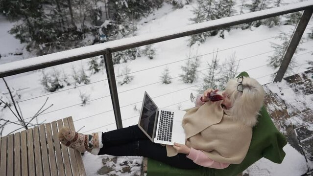Top view of woman with laptop and glass of wine