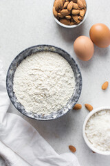 overhead view of mise en place for almond biscotti dough, ingredients for making almond cantucci cookie on a marble countertop