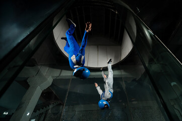 A man and a woman enjoy flying together in a wind tunnel. Free fall simulator