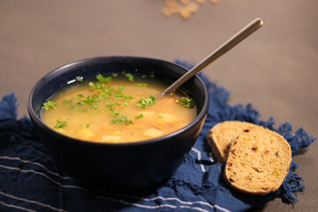 Close up of vegetarian yellow peas soup in bowl with slices of olive bread