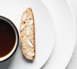 overhead view of coffee and almond biscotti on a white plate, almond cantucci cookies on a white plate, flatlay of coffee biscotti cookies or twice baked cookies