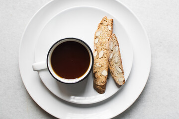 overhead view of coffee and almond biscotti on a white plate, almond cantucci cookies on a white plate, flatlay of coffee biscotti cookies or twice baked cookies