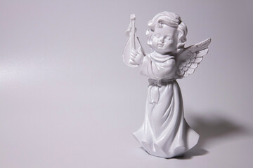 Angel statue isolated on white background. White stone sculpture of praying cherub.