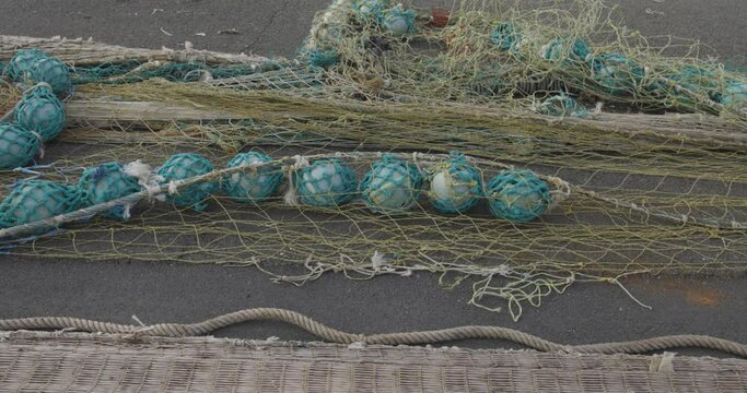 Nylon marine fishing nets drying on pavement in harbour