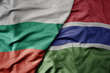 Obraz premium big waving national colorful flag of gambia and national flag of bulgaria .