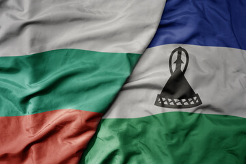 big waving national colorful flag of lesotho and national flag of bulgaria .