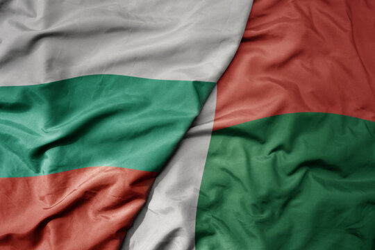 big waving national colorful flag of madagascar and national flag of bulgaria .