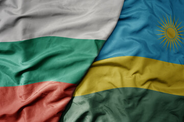 big waving national colorful flag of rwanda and national flag of bulgaria .